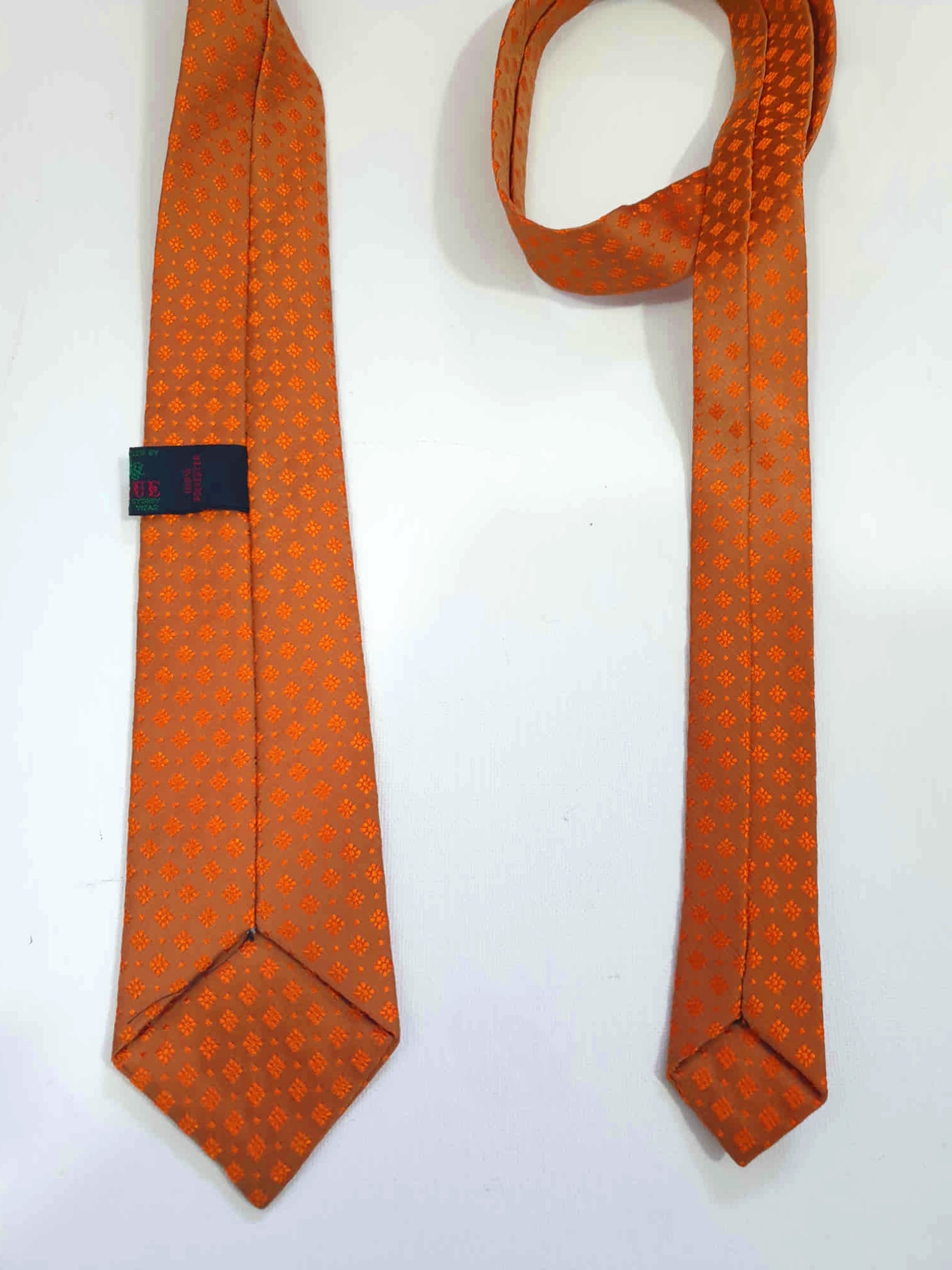 Burnt orange tie and pocket square set for a pop of colour. 
Brocade set - The fabric is woven to show a matt background and shiny medallion designs. 100% polyester. Brand is Vogue of Sydney - 1960s.
