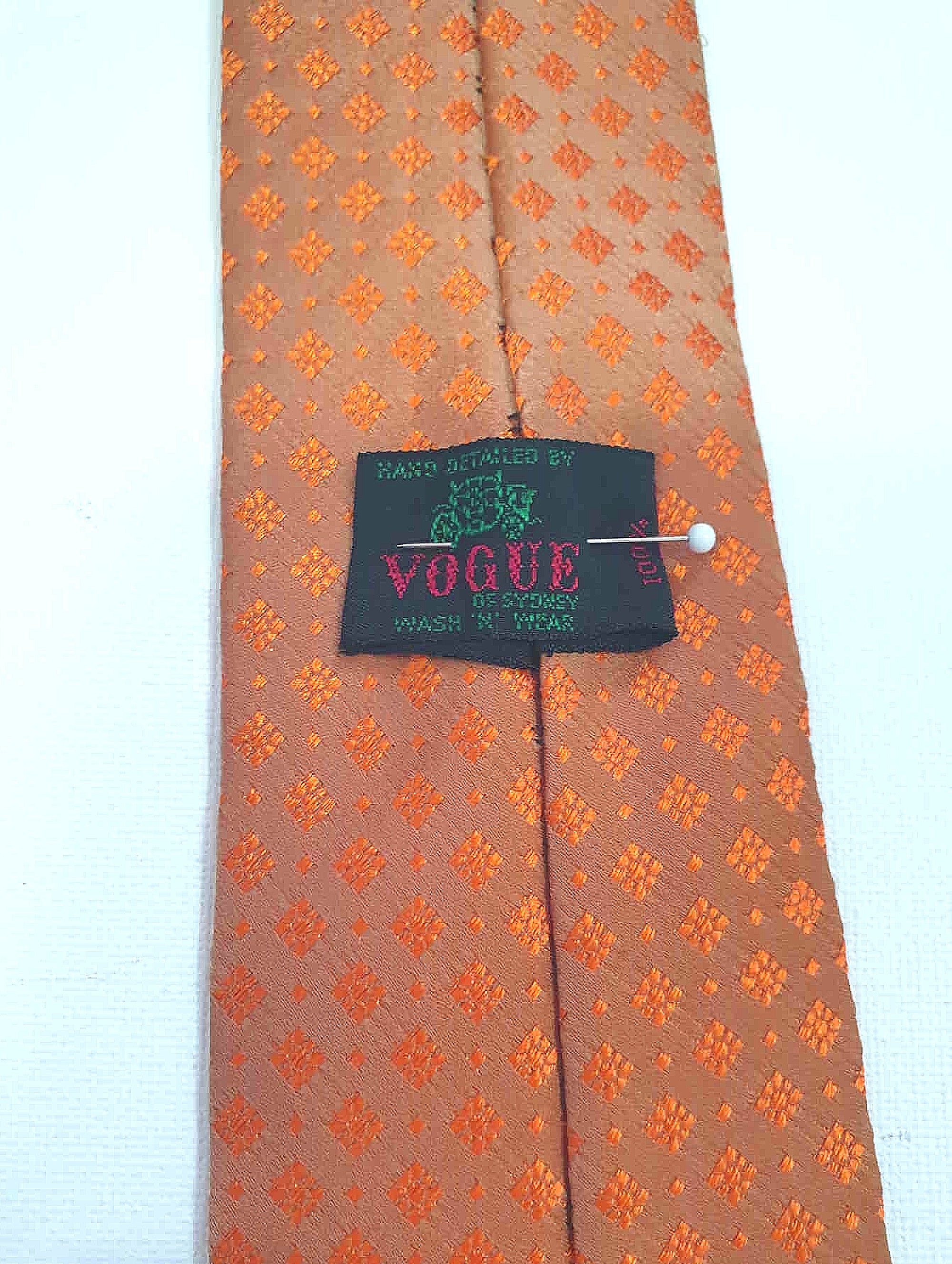 Burnt orange tie and pocket square set for a pop of colour. 
Brocade set - The fabric is woven to show a matt background and shiny medallion designs. 100% polyester. Brand is Vogue of Sydney - 1960s.