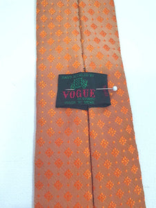 Burnt orange tie and pocket square set for a pop of colour. 
Brocade set - The fabric is woven to show a matt background and shiny medallion designs. 100% polyester. Brand is Vogue of Sydney - 1960s.