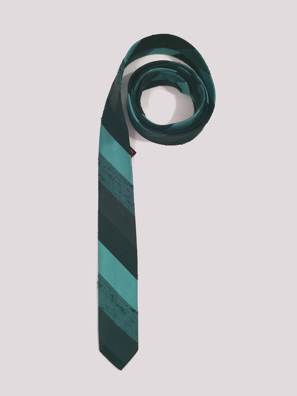 Super skinny tie in shades of grey-blue, grey and black. The grey band has a black fleck. Fabric is 100% polyester. Label reads "Superloom by Rodney" - 1960s. Blade width 3.7 cm (1.5") Length 130 cm (51") Excellent condition.