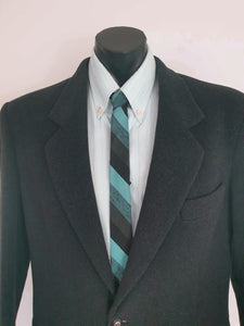 Super skinny tie in shades of grey-blue, grey and black. The grey band has a black fleck. Fabric is 100% polyester. Label reads "Superloom by Rodney" - 1960s. Blade width 3.7 cm (1.5") Length 130 cm (51") Excellent condition.