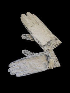 New old stock - beautiful lace bridal gloves with diamante trim, unsold stock from a former 1980s bridal boutique. White lace gloves are below-wrist length and have a shaped opening trimmed with more lace and a line of diamantes. 100% nylon. Made in Hong Kong for Jendi - 1980s.