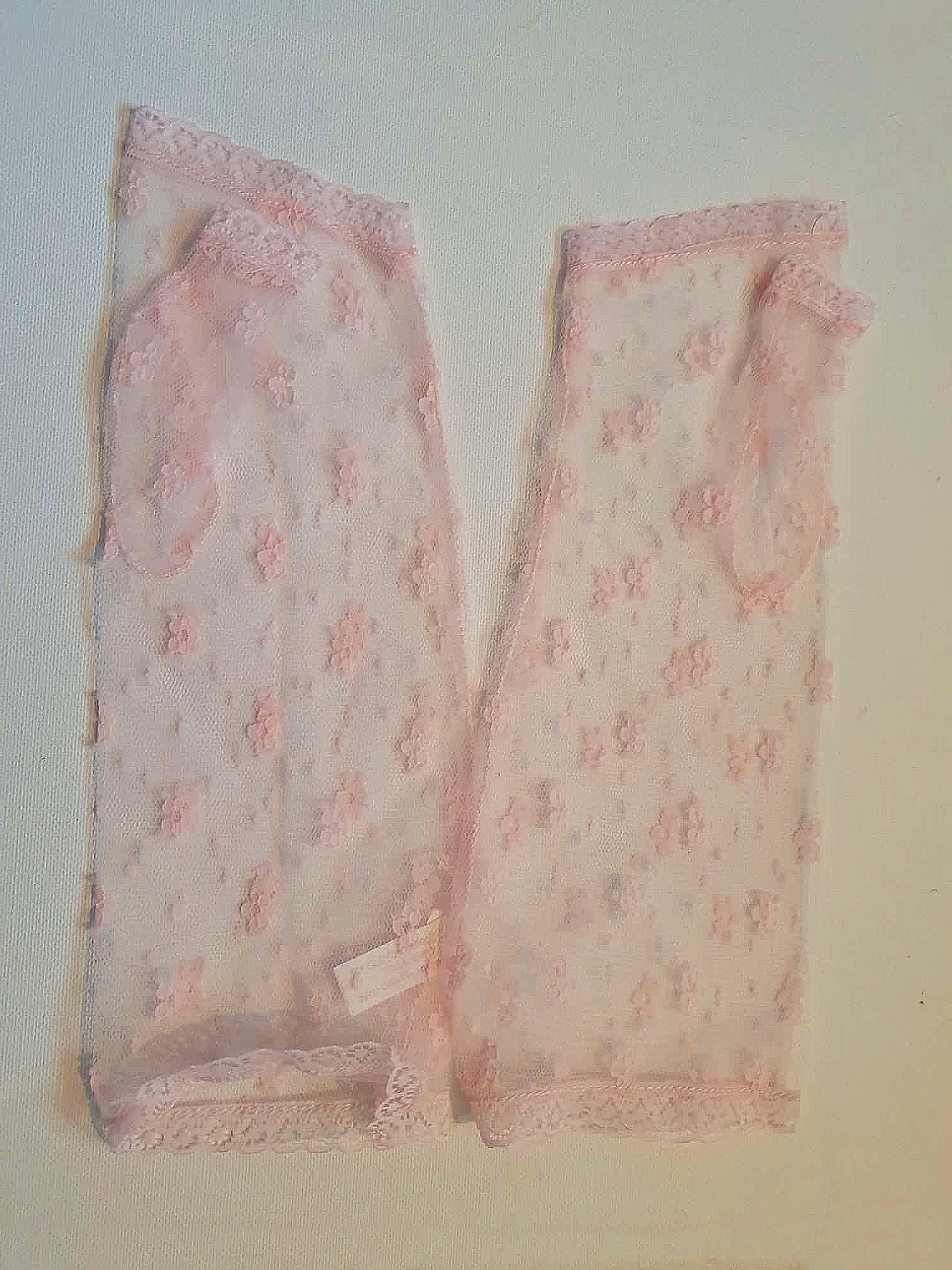 New old stock - Dainty lace mitts for a special occasion. Pale pink lace mitts or fingerless gloves are mid-forearm length. Trimmed with narrow lace at the edges. 100% nylon. Made in Hong Kong. No brand label. From a former 1980s bridal boutique. Mint condition - brand new and never used.