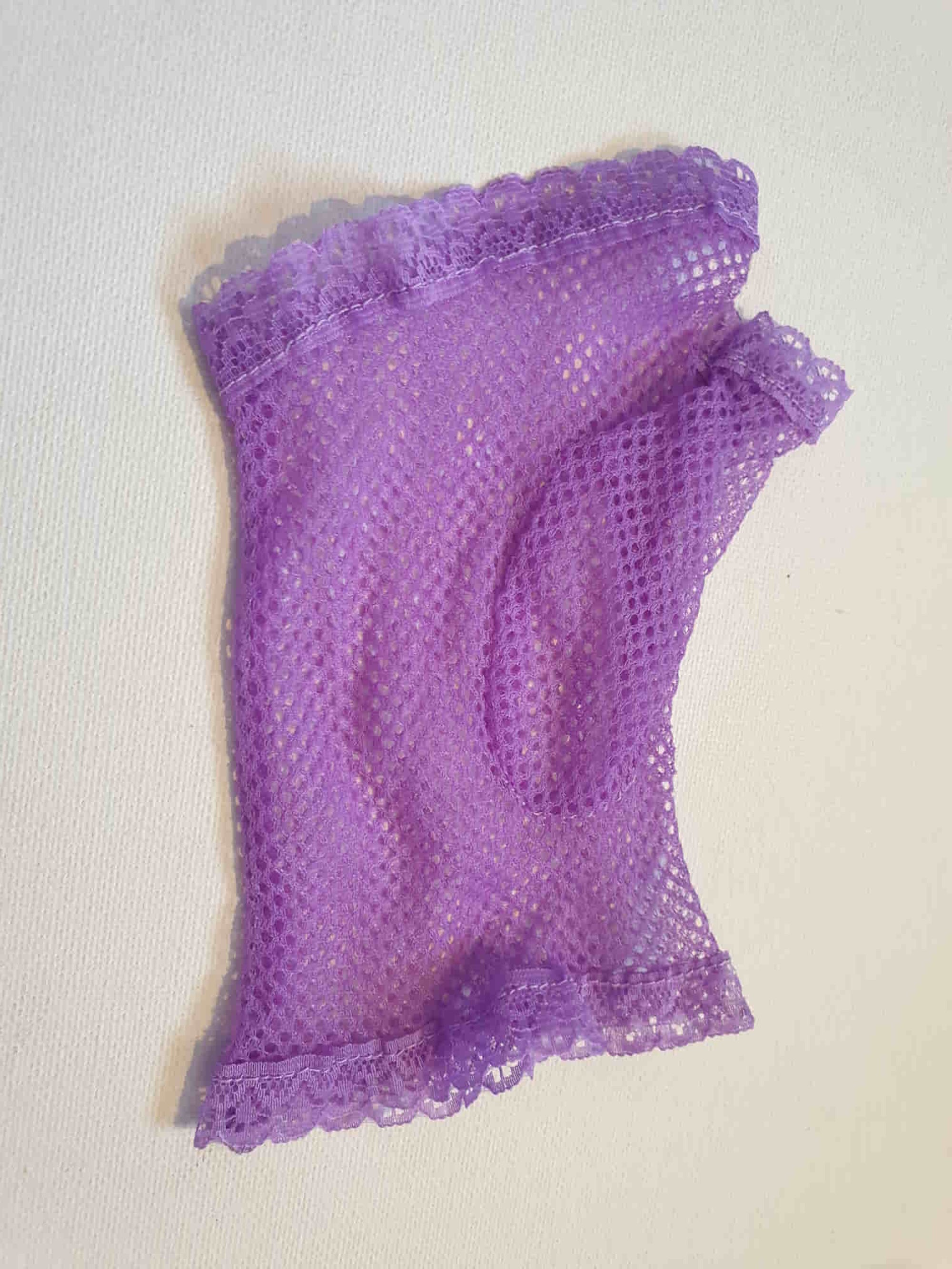 New old stock vintage purple fingerless gloves or mitts. Mitts are wrist length and are finished at all edges with lace trim. Colour is light purple - mauve - lavender. Fabric is nylon mesh. Made in Hong Kong. Unsold stock from a former 1980s bridal boutique. Small to Medium