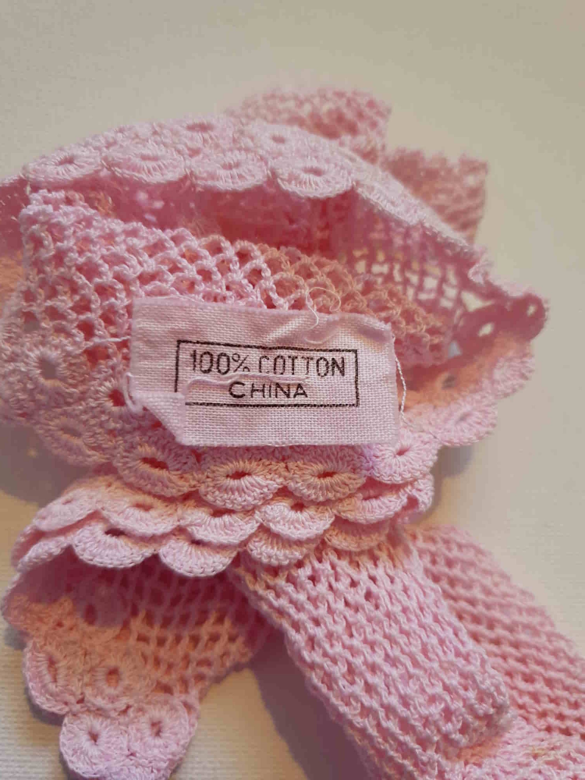 New Old Stock - Pink fingerless gloves or mitts crocheted in cotton. The top is open for four fingers, not separate finger sections apart from the thumb. Made in China. From a former bridal store operating in the 1980s.