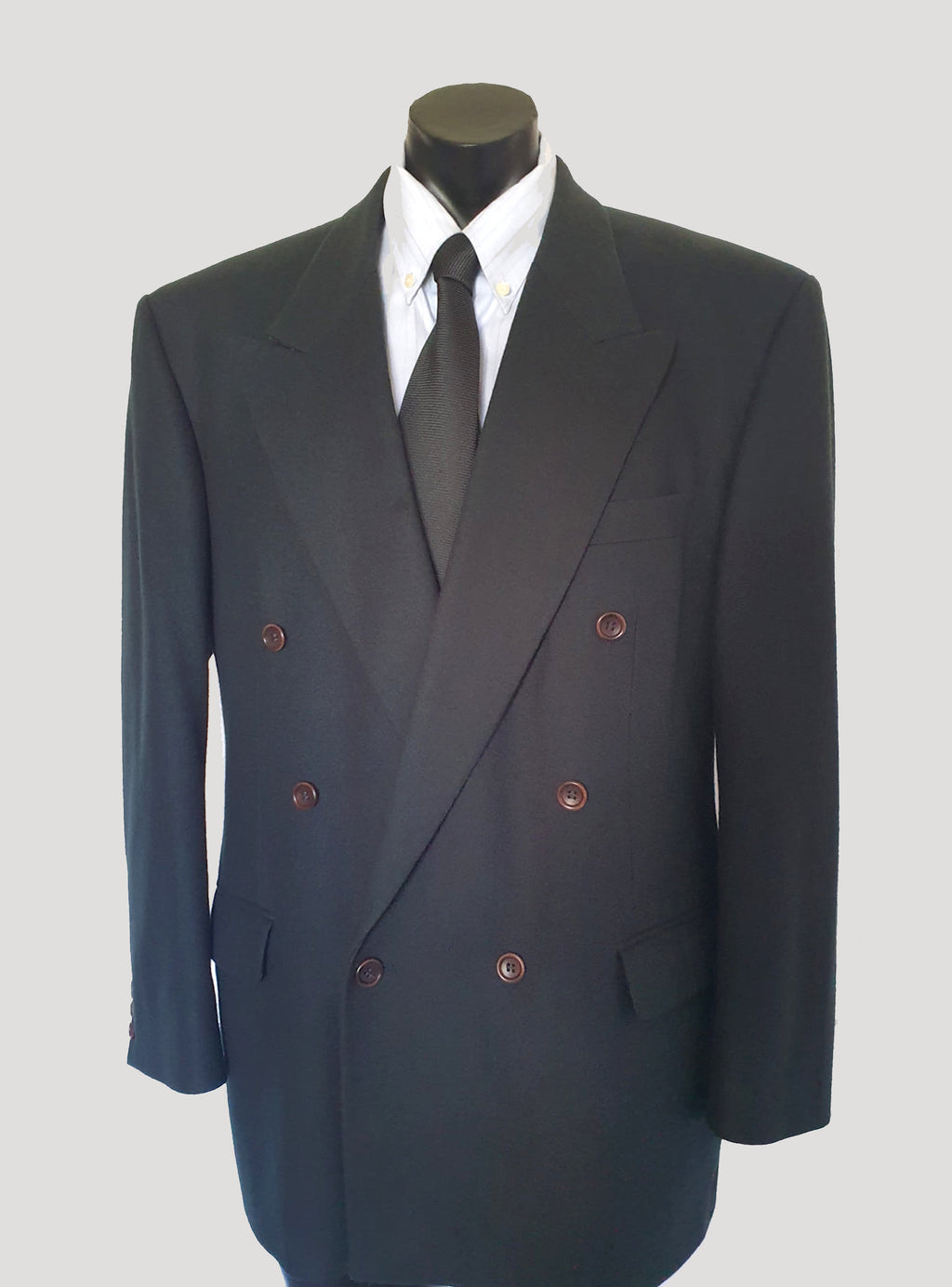 Very dark green (can appear black) double-breasted jacket has peak lapels and no rear vent. Six button front stance and three button sleeve trim. Two front flapped pockets, breast pocket and three interior pockets. Fully lined. Fabric is 70% wool, 20% nylon and 10% cashmere. 1990s, 42M