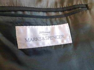 Very dark green (can appear black) double-breasted jacket has peak lapels and no rear vent. Six button front stance and three button sleeve trim. Two front flapped pockets, breast pocket and three interior pockets. Fully lined. Fabric is 70% wool, 20% nylon and 10% cashmere. 1990s, 42M