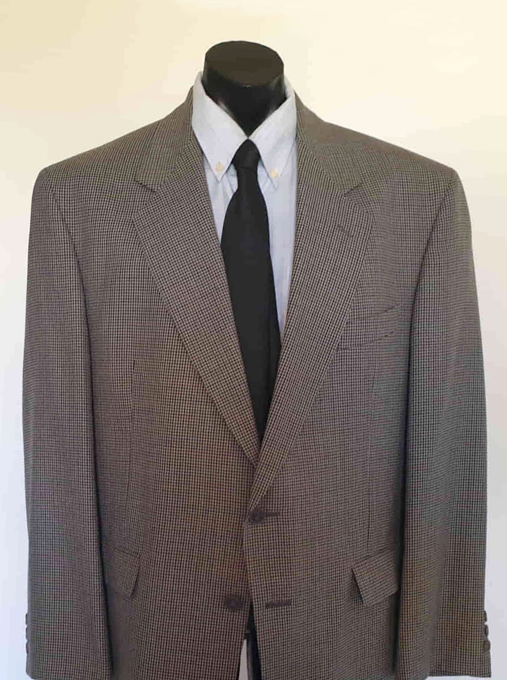 Classic houndstooth sports jacket has a pattern in maroon/brown and green/grey on a beige ground. There are two flapped pockets, still stitched down, breast pocket and two interior pockets. Two button closure and three button sleeve trim. No rear vent. Fully lined. Fabric is 45% wool, 55% polyester. Tag says "Finest European fabric". Brand is Lubiani - 1980s. Size 48R - XL