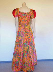 Superbly made gown in bright orange and pink florals in a very swishy parachute type fabric. 1950s style dress has wrap over sleeves exposing the vivid orange red lining. Square neckline. The skirt is wrapped at the front and pleated into the waist. It's very full at the back. Closes at the back with a nylon zip. The fabric is shot so that it can appear pink from different angles. The gown looks to have been made by a professional dressmaker  probably late 20th century. Medium