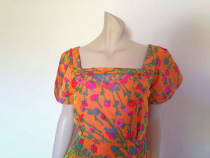 Superbly made gown in bright orange and pink florals in a very swishy parachute type fabric. 1950s style dress has wrap over sleeves exposing the vivid orange red lining. Square neckline. The skirt is wrapped at the front and pleated into the waist. It's very full at the back. Closes at the back with a nylon zip. The fabric is shot so that it can appear pink from different angles. The gown looks to have been made by a professional dressmaker  probably late 20th century. Medium