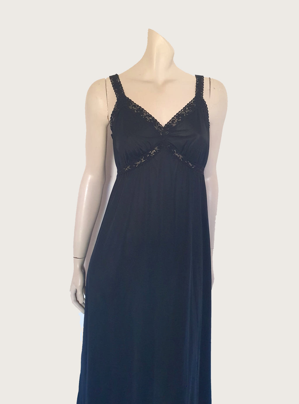 Black maxi slip originally worn under an evening gown or funky maxi dress. You can use it as a slip, nightgown or dress. It has stretch lace straps and bodice trim. Straps are no adjustable. Fabric is "no cling" nylon. Brand is Osti - 1970s. Medium
