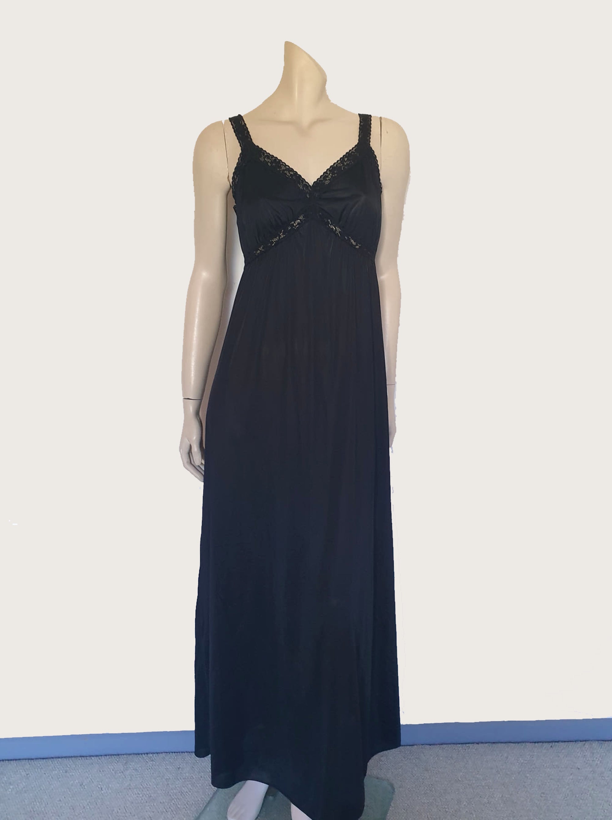 Black maxi slip originally worn under an evening gown or funky maxi dress. You can use it as a slip, nightgown or dress. It has stretch lace straps and bodice trim. Straps are no adjustable. Fabric is "no cling" nylon. Brand is Osti - 1970s. Medium