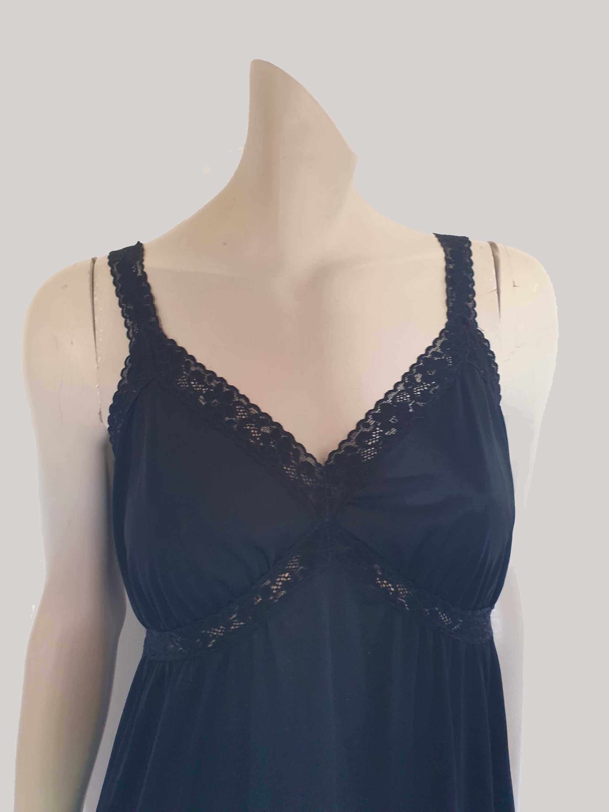 Black maxi slip originally worn under an evening gown or funky maxi dress. You can use it as a slip, nightgown or dress. It has stretch lace straps and bodice trim. Straps are no adjustable. Fabric is "no cling" nylon. Brand is Osti - 1970s. Medium