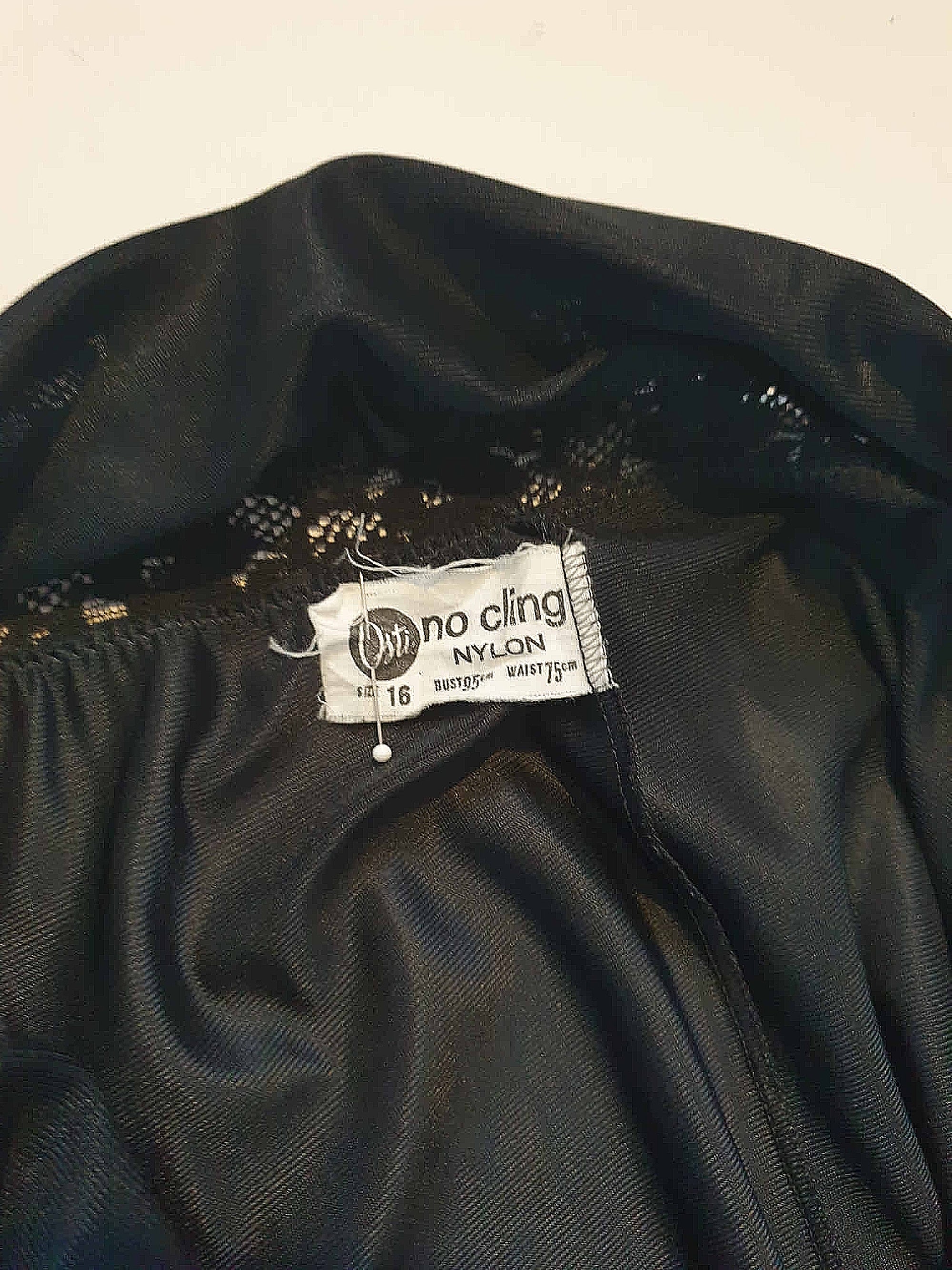 Black maxi slip originally worn under an evening gown or funky maxi dress. You can use it as a slip, nightgown or dress. It has stretch lace straps and bodice trim. Straps are no adjustable. Fabric is "no cling" nylon. Brand is Osti - 1970s. Medium