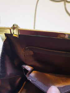 Beige mesh purse can either be used as a shoulder bag or as a clutch. Gold frame and kiss clasp and beige rat tail chain. The interior is brown satin, and has one zipped compartment and a pocket. The chain folds into the bag for use as a clutch. Brand is GC, also known as Goldcrest. 1970s-1980s.
