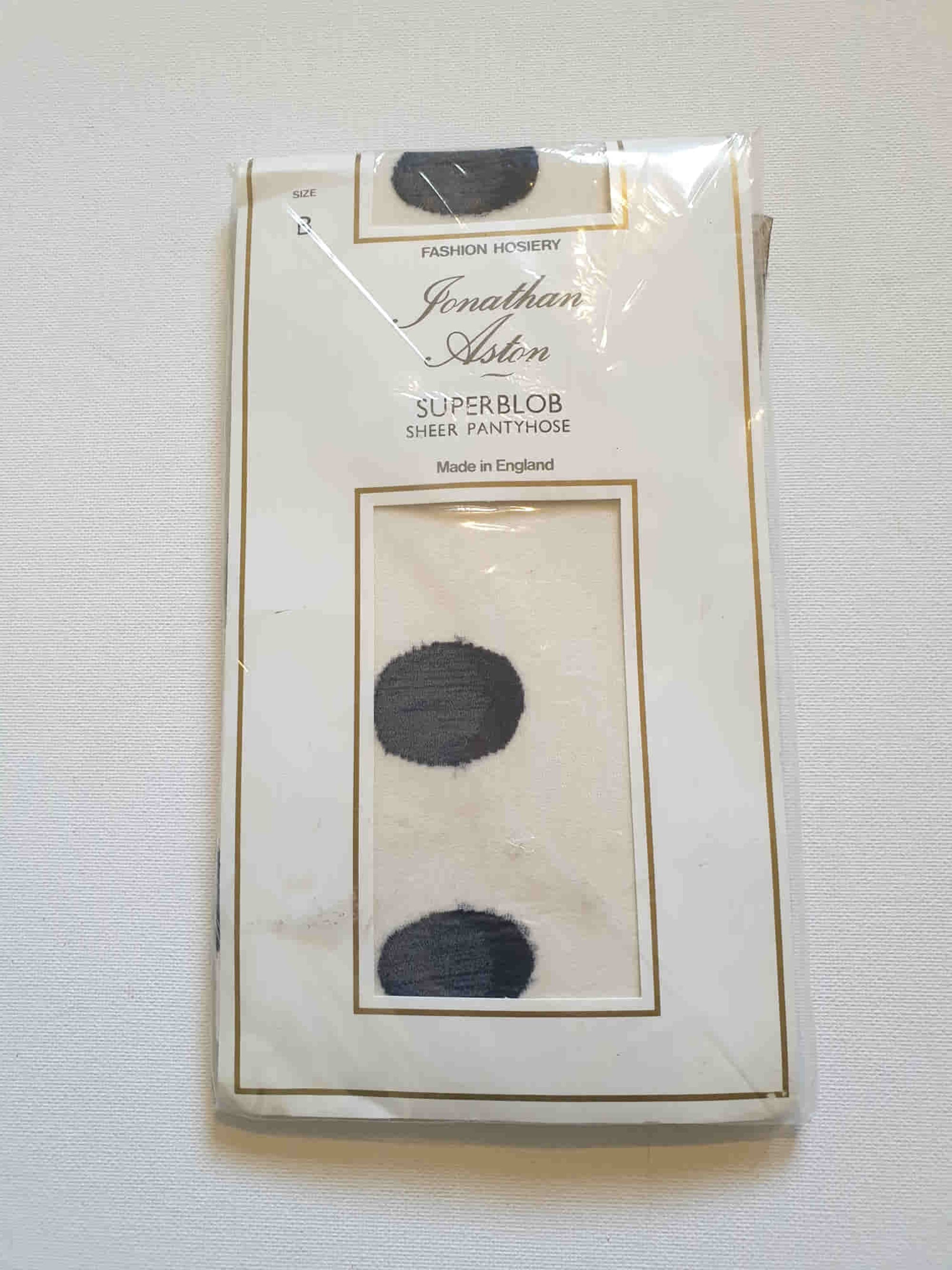 Make a statement with these Superblob tights by luxury hosiery brand Jonathan Aston. Sheer white pantyhose/tights with very large black polka dots. 100% nylon. Made in England - 1980s. Fits 163-180 cm/59-75 kg (5'4"-5'9"/130-165 lbs.) New old stock, in the original packaging, unworn.
