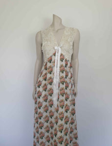 Beautiful and elegant nightgown. Long nightgown has a pink and green floral print on a cream ground. The fitted front bodice is cream stretch lace. There's also panel of lace at centre back. Trimmed with a satin bow and long ribbons beneath the bust. There are no labels, but the fabric is polyester georgette. 1980s. Bust 92 cm (36")