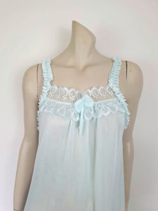 Pretty above knee length blue nightgown has ruffled straps and armholes, lace bodice and front bow. Ruffle at the hemline. Fabric is nylon. No brand label. Made in China. 1980s-1990s.