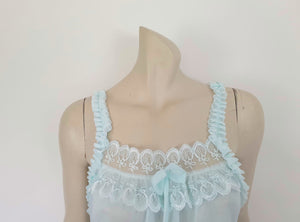 Pretty above knee length blue nightgown has ruffled straps and armholes, lace bodice and front bow. Ruffle at the hemline. Fabric is nylon. No brand label. Made in China. 1980s-1990s.