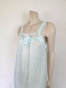 Pretty above knee length blue nightgown has ruffled straps and armholes, lace bodice and front bow. Ruffle at the hemline. Fabric is nylon. No brand label. Made in China. 1980s-1990s.
