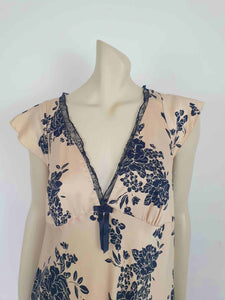 Long beige satin nightgown with large black floral print and flared capped sleeves. The skirt falls from beneath the bust. Slit to the thigh on one side. The V neck is trimmed with narrow black lace and a bow. Elasticised across the back. Fabric is polyester satin. Brand is illegible. 1990s-Y2K?