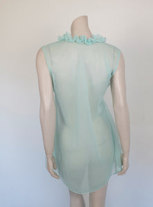 Sheer aqua mini nightgown has a crossover V neck with a drawstring beneath at the front. Double ruffle at the neckline. The back is quite full. Mid-thigh length. It's made from two layers of totally sheer nylon. Brand is Linella - 1960s. Medium.
