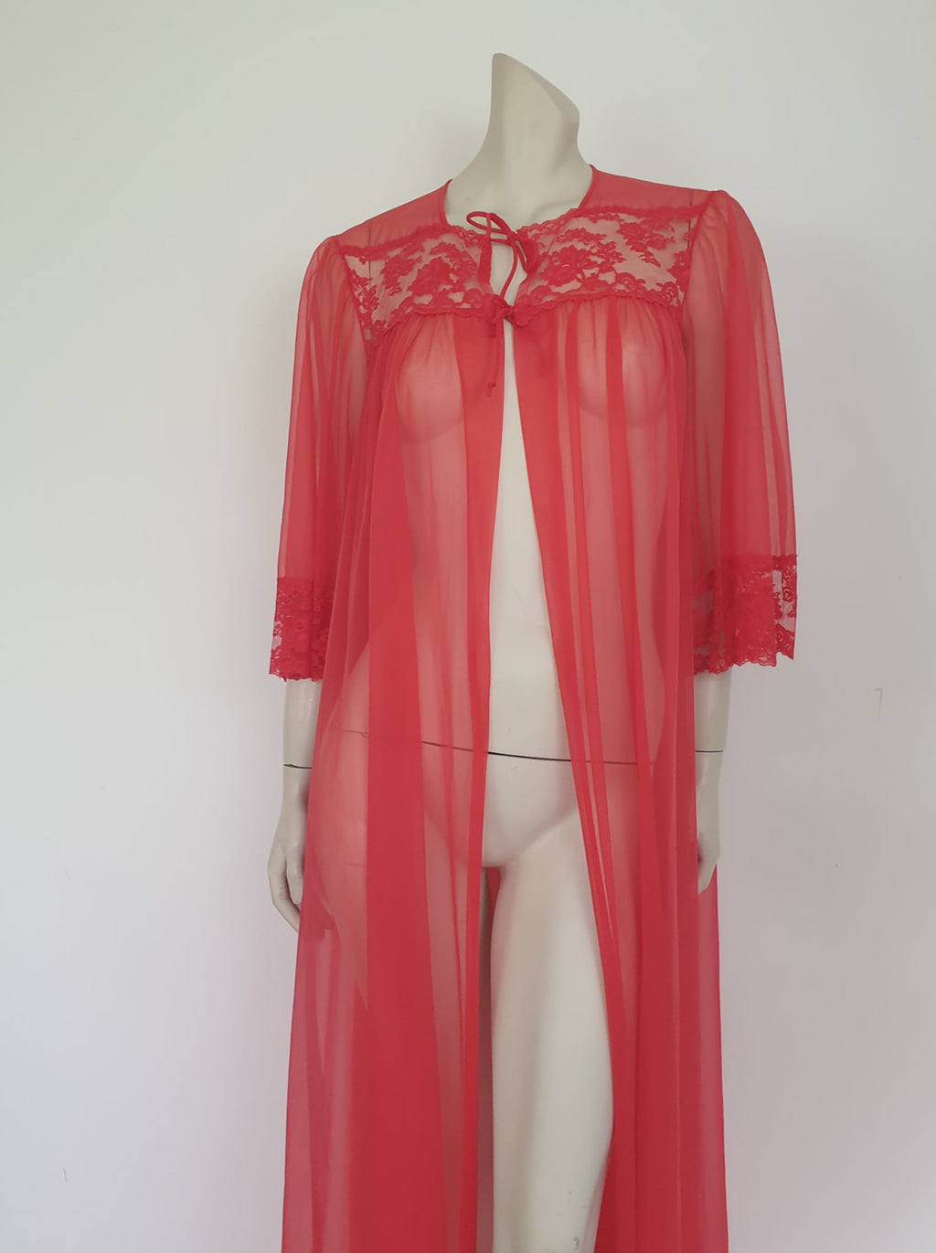 Glamourous  robe or peignoir is very sheer and has full three-quarter length sleeves trimmed with wide lace. The same lace is inserted across the front as a yoke. Closes with a double tie at the neck. Fabric is nylon. Made in the USA for Sears - 1960s. Medium
