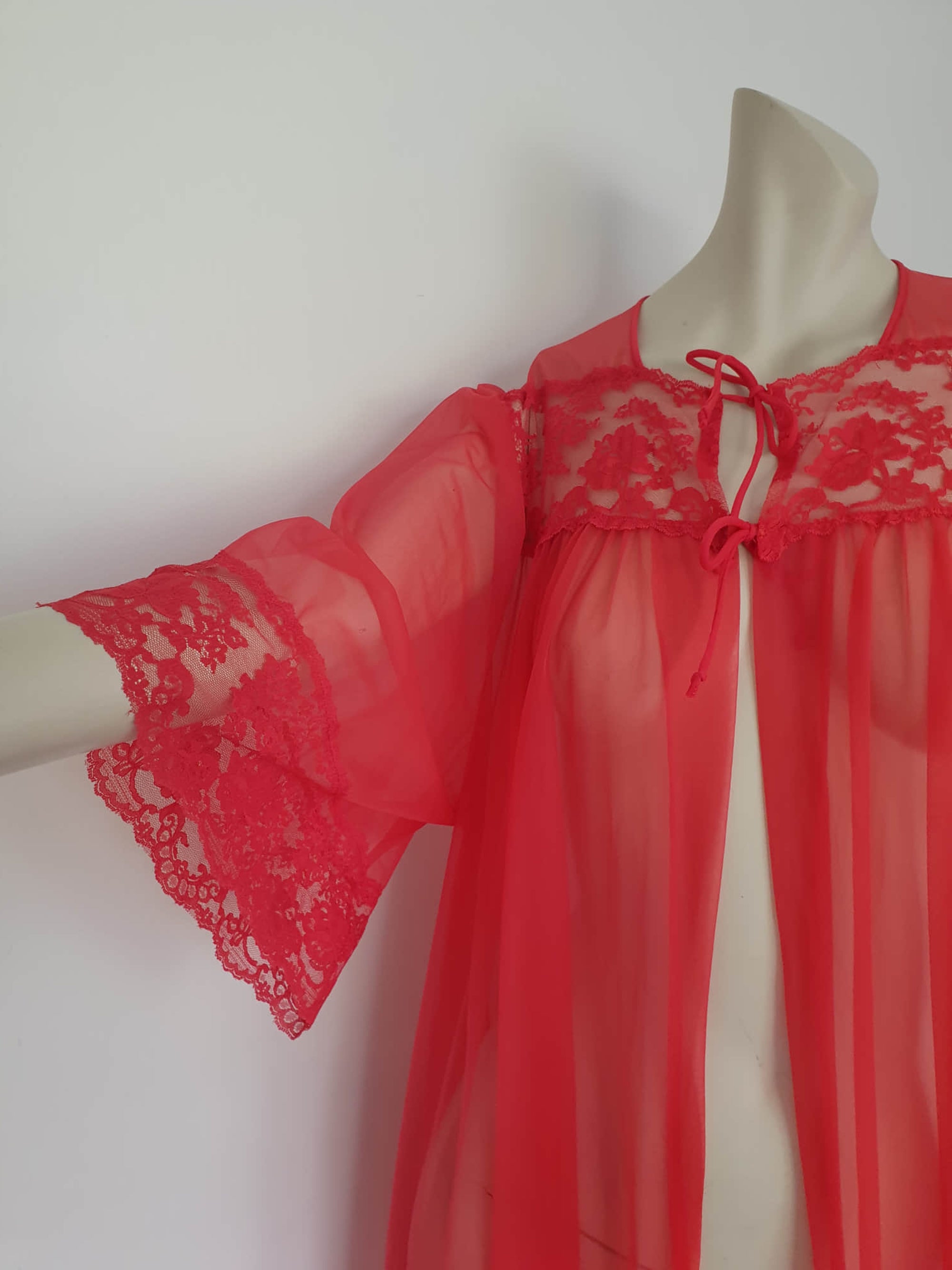 Glamourous  robe or peignoir is very sheer and has full three-quarter length sleeves trimmed with wide lace. The same lace is inserted across the front as a yoke. Closes with a double tie at the neck. Fabric is nylon. Made in the USA for Sears - 1960s. Medium