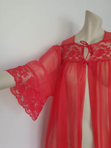 Glamourous  robe or peignoir is very sheer and has full three-quarter length sleeves trimmed with wide lace. The same lace is inserted across the front as a yoke. Closes with a double tie at the neck. Fabric is nylon. Made in the USA for Sears - 1960s. Medium