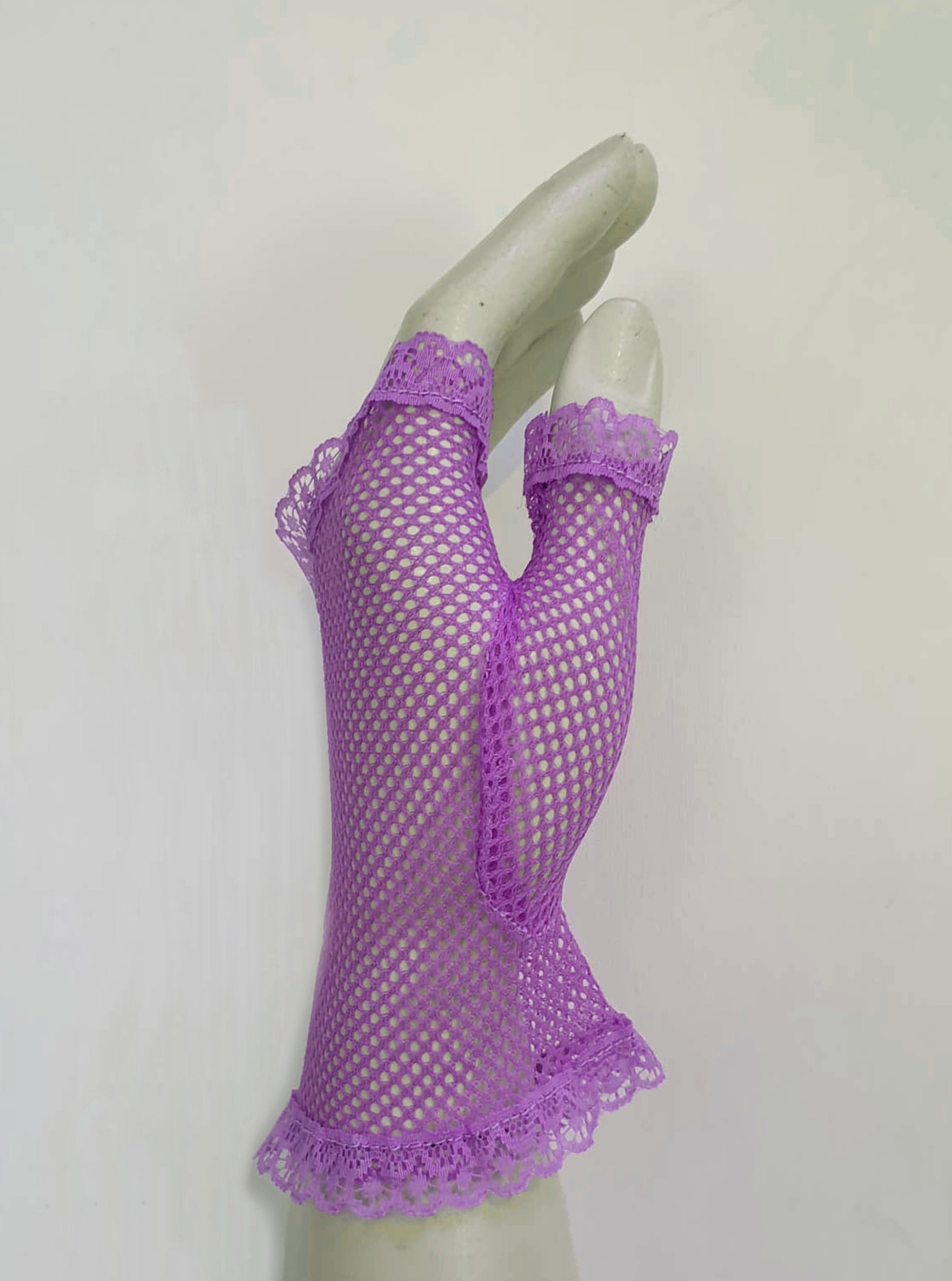 New old stock vintage purple fingerless gloves or mitts. Mitts are wrist length and are finished at all edges with lace trim. Colour is light purple - mauve - lavender. Fabric is nylon mesh. Made in Hong Kong. Unsold stock from a former 1980s bridal boutique. Small to Medium