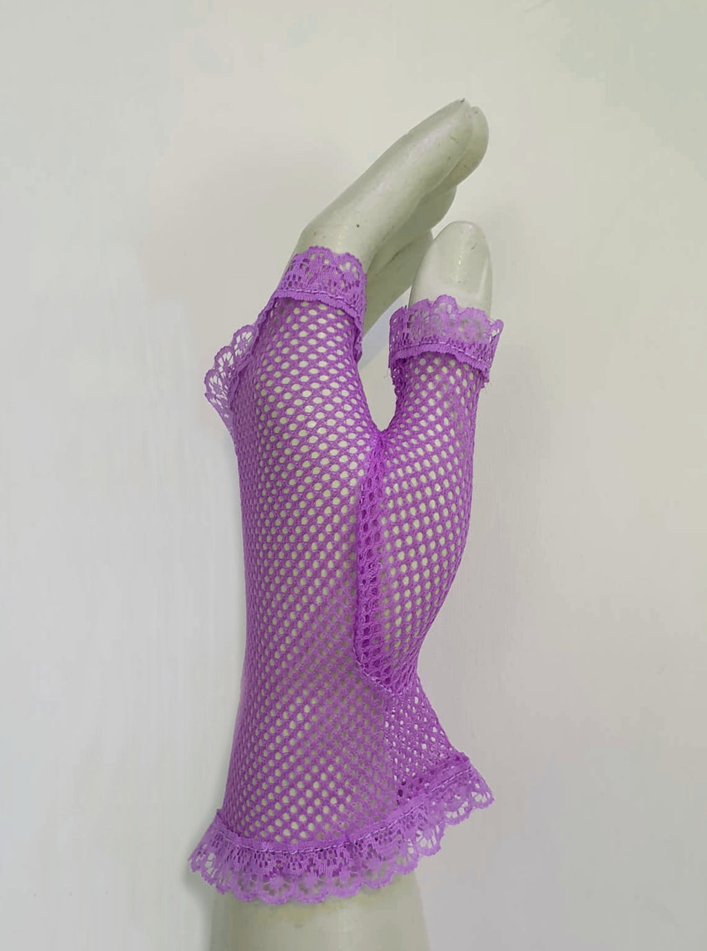 New old stock vintage purple fingerless gloves or mitts. Mitts are wrist length and are finished at all edges with lace trim. Colour is light purple - mauve - lavender. Fabric is nylon mesh. Made in Hong Kong. Unsold stock from a former 1980s bridal boutique. Small to Medium