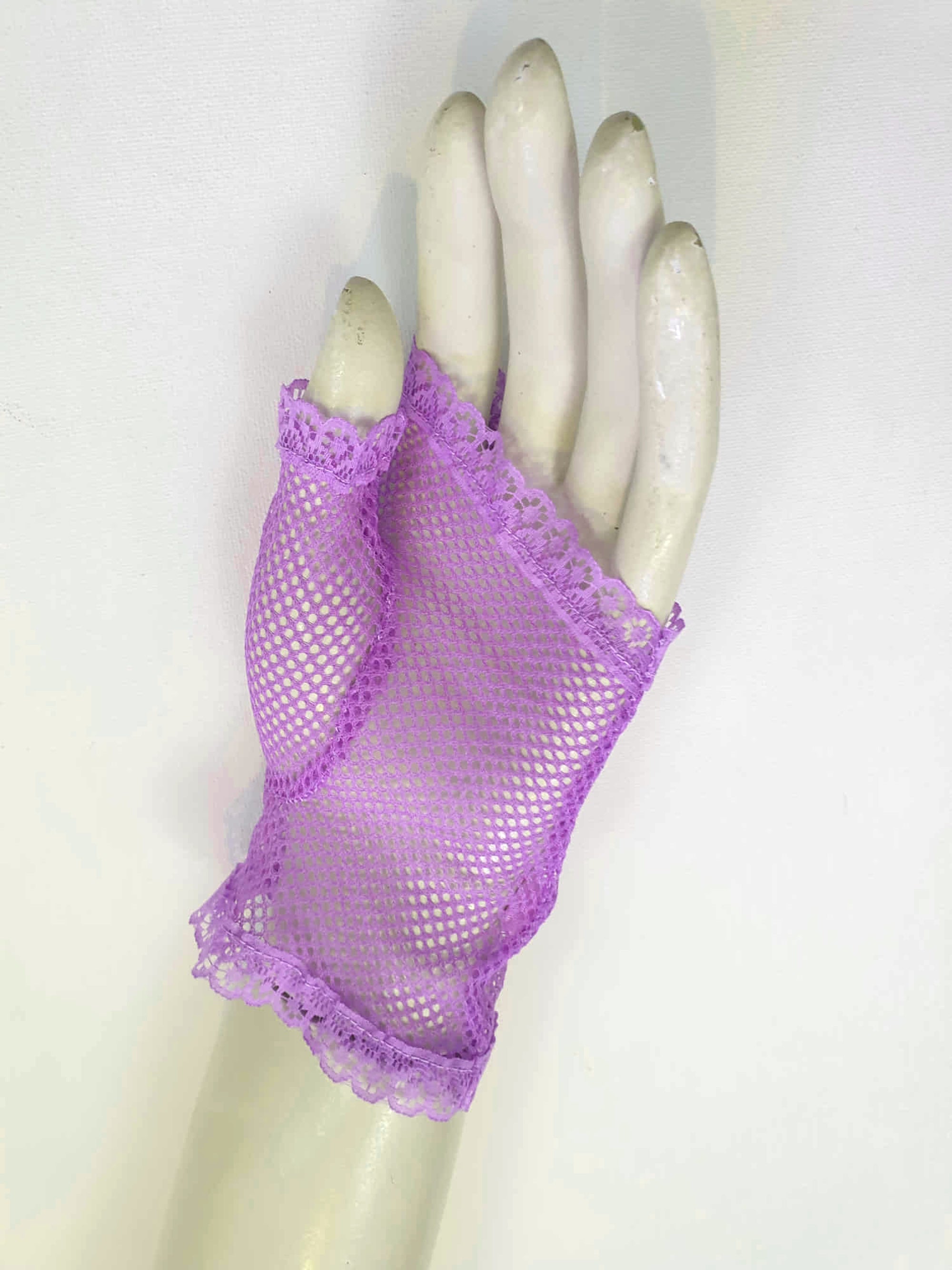 New old stock vintage purple fingerless gloves or mitts. Mitts are wrist length and are finished at all edges with lace trim. Colour is light purple - mauve - lavender. Fabric is nylon mesh. Made in Hong Kong. Unsold stock from a former 1980s bridal boutique. Small to Medium