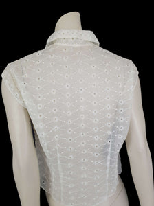 Beautiful sheer white nylon blouse embroidered all over in the eyelet style. 
The blouse has a peter pan collar and capped sleeves. It's darted in at the waist as it was designed to be worn with high waisted skirts. Closes to above waist level with clear plastic buttons. Fabric is nylon. No brand label. Late 1950s or very early 1960s. Medium