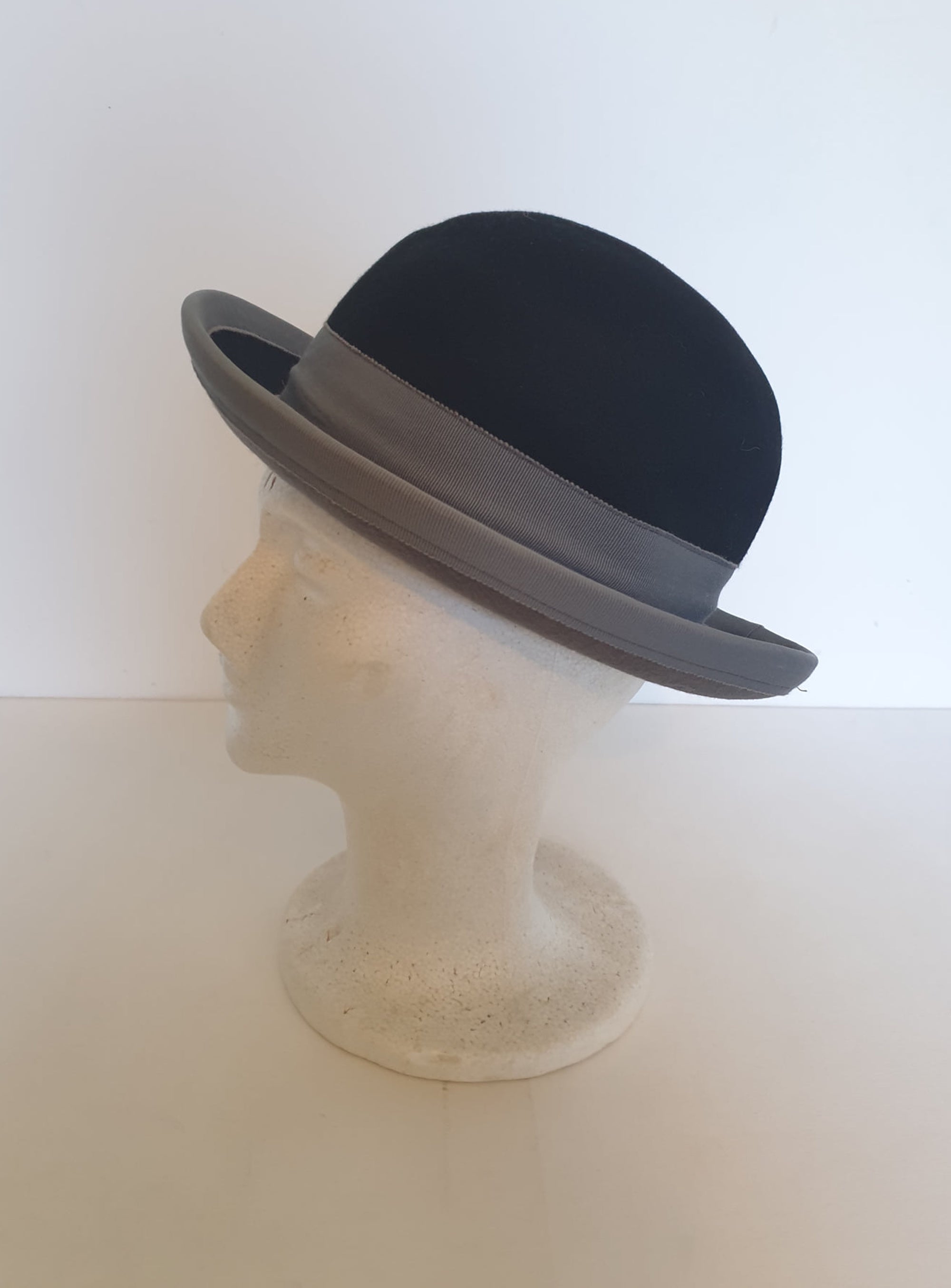 Felted bowler style black hat with grey grosgrain hatband and brim binding. Wear it bowler style with the brim up or turn the brim down for a bit of sass. Made in Denmark for Andersen &amp; Berner. 1980s??