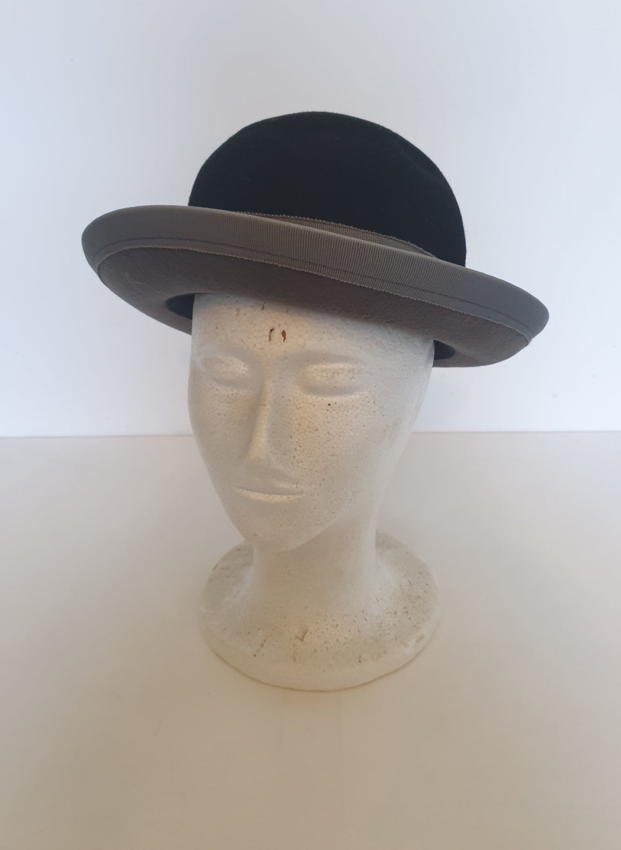Felted bowler style black hat with grey grosgrain hatband and brim binding. Wear it bowler style with the brim up or turn the brim down for a bit of sass. Made in Denmark for Andersen &amp; Berner. 1980s??