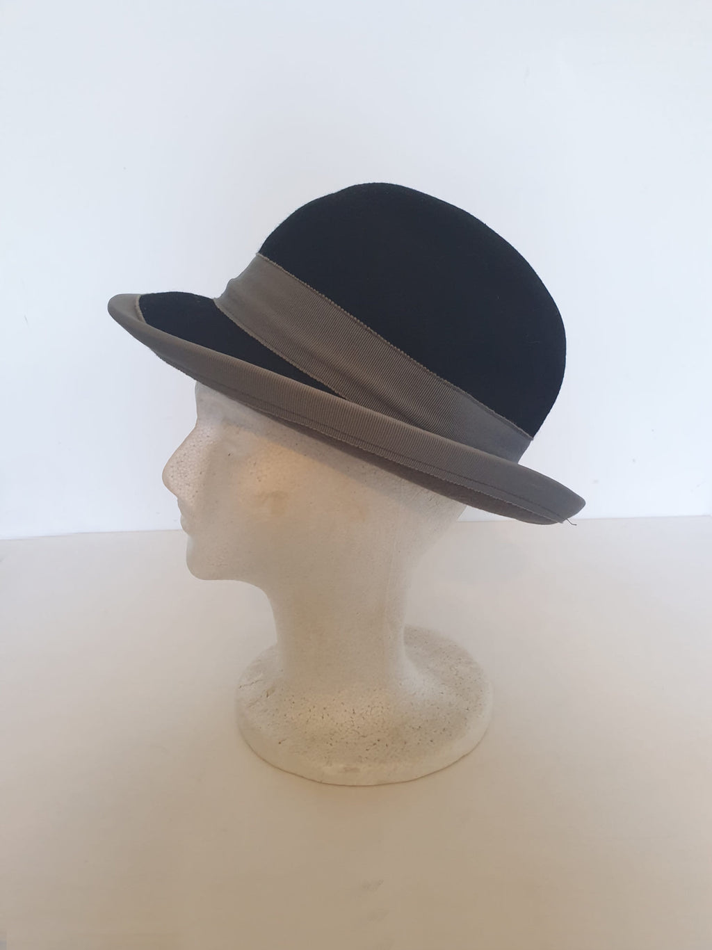 Felted bowler style black hat with grey grosgrain hatband and brim binding. Wear it bowler style with the brim up or turn the brim down for a bit of sass. Made in Denmark for Andersen &amp; Berner. 1980s??