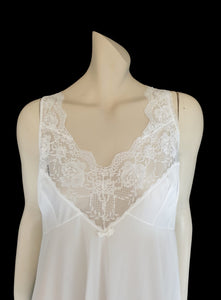 Below-knee to mid-calf length white midi slip has lace over the bust extending into wide front straps. Deep lace border also has ribbon trim. The straps are not adjustable. Fabric is nylon. Made in Australia. There is no brand label. 1980s-1990s. Medium