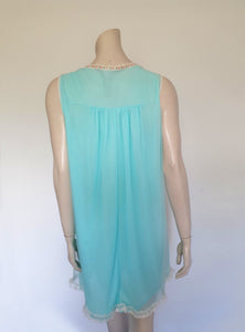 Very cute little aqua mini nightgown with floral braid and lace trim at the V neckline. The same lace also trims the hem. The nightie has a sheer overlay with an opaque layer of fabric beneath. Fabric is nylon. Brand is Irene Lingerie - Late 1960s - 1970s. Small.