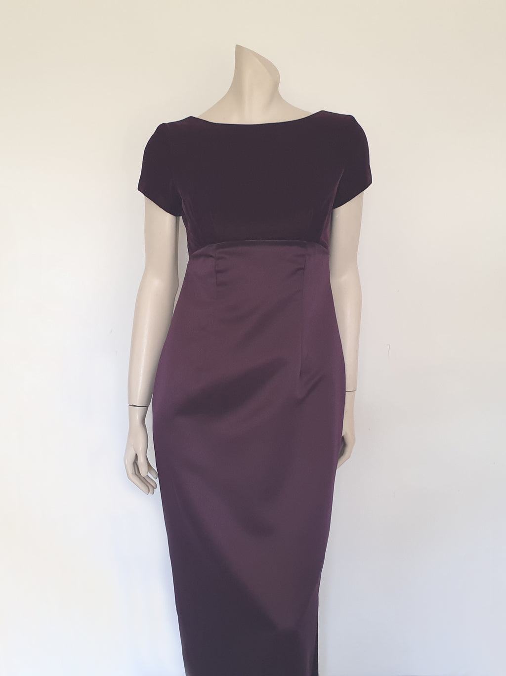 Beautiful and elegant aubergine formal sheath style gown with velvet bodice and stunning rear view. The gown has a wide neckline cut low at the back where it features a diamante studded bow extending into a narrow train over the the rear of the dress. Beneath the train the gown is slit to above the knee. The bodice is velvet and the satin skirt falls from beneath the bust. Closes at the back with a zip and a fancy button. Fabric is polyester. Made in Australia. Brand is Aurelie - 1980s. XS