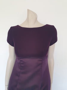 Beautiful and elegant aubergine formal sheath style gown with velvet bodice and stunning rear view. The gown has a wide neckline cut low at the back where it features a diamante studded bow extending into a narrow train over the the rear of the dress. Beneath the train the gown is slit to above the knee. The bodice is velvet and the satin skirt falls from beneath the bust. Closes at the back with a zip and a fancy button. Fabric is polyester. Made in Australia. Brand is Aurelie - 1980s. XS
