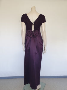 Beautiful and elegant aubergine formal sheath style gown with velvet bodice and stunning rear view. The gown has a wide neckline cut low at the back where it features a diamante studded bow extending into a narrow train over the the rear of the dress. Beneath the train the gown is slit to above the knee. The bodice is velvet and the satin skirt falls from beneath the bust. Closes at the back with a zip and a fancy button. Fabric is polyester. Made in Australia. Brand is Aurelie - 1980s. XS