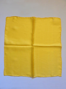 Yellow silk pocket square has hand rolled edges. Tag says 100% pure silk - Made in China.