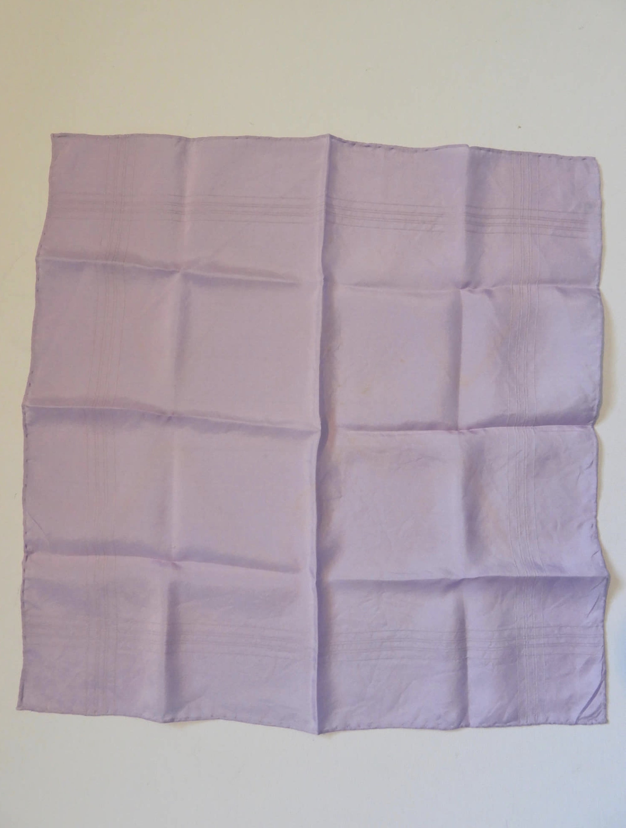 Large lavender coloured pocket handkerchief for adding just a touch of colour to your suit. The hanky has woven borders and hand rolled edges. The colour is very pale, not like the close ups. Pure silk. Made in England and marked Macclesfield Silk with an embroidered label.