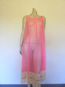 Super sexy sheer hot pink negligee nightgown. Has some issues but presents well. Very full negligee has wide neckline trimmed with cream lace. The hem is trimmed with a deep border of cream lace. There's a fixed tie at centre back which can tie in the fullness if you prefer. I have appliqued two flowers over two large holes in the front. Fabric is a single layer of sheer nylon. Made in the USA for Berkliff - 1960s. Small to Medium.