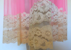 Super sexy sheer hot pink negligee nightgown. Has some issues but presents well. Very full negligee has wide neckline trimmed with cream lace. The hem is trimmed with a deep border of cream lace. There's a fixed tie at centre back which can tie in the fullness if you prefer. I have appliqued two flowers over two large holes in the front. Fabric is a single layer of sheer nylon. Made in the USA for Berkliff - 1960s. Small to Medium.