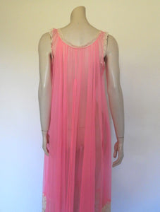 Super sexy sheer hot pink negligee nightgown. Has some issues but presents well. Very full negligee has wide neckline trimmed with cream lace. The hem is trimmed with a deep border of cream lace. There's a fixed tie at centre back which can tie in the fullness if you prefer. I have appliqued two flowers over two large holes in the front. Fabric is a single layer of sheer nylon. Made in the USA for Berkliff - 1960s. Small to Medium.
