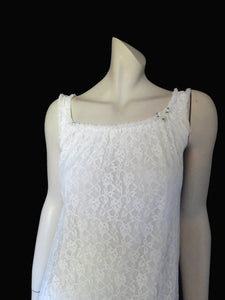 Pretty white lace knee-length nightgown would also make a sweet dress.
The nightie has scooped neckline front and back, horizontal tucks at the hem and ruffle trim at the neckline, armholes and hem. The neckline is trimmed with flower appliques. There is an opaque layer beneath the lace outer layer and this hangs down a little below the lace at the bottom. Nylon lace with acetate lining. Brand is St Mark, 1960s. Small.