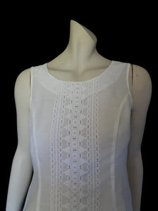 Tennis dress is decorated at centre front with eyelet embroidery. It has princess seaming and closes at the back with a zipper. The dress is semi sheer. The fabric appears to be an early form of polyester or maybe nylon, there's no fabric tag. The label reads "A Belle Garment Exclusive Model" - early 1960s. Medium