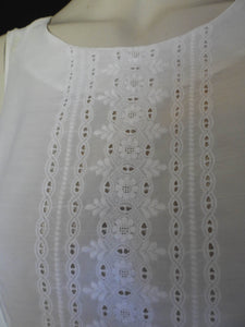Tennis dress is decorated at centre front with eyelet embroidery. It has princess seaming and closes at the back with a zipper. The dress is semi sheer. The fabric appears to be an early form of polyester or maybe nylon, there's no fabric tag. The label reads "A Belle Garment Exclusive Model" - early 1960s. Medium