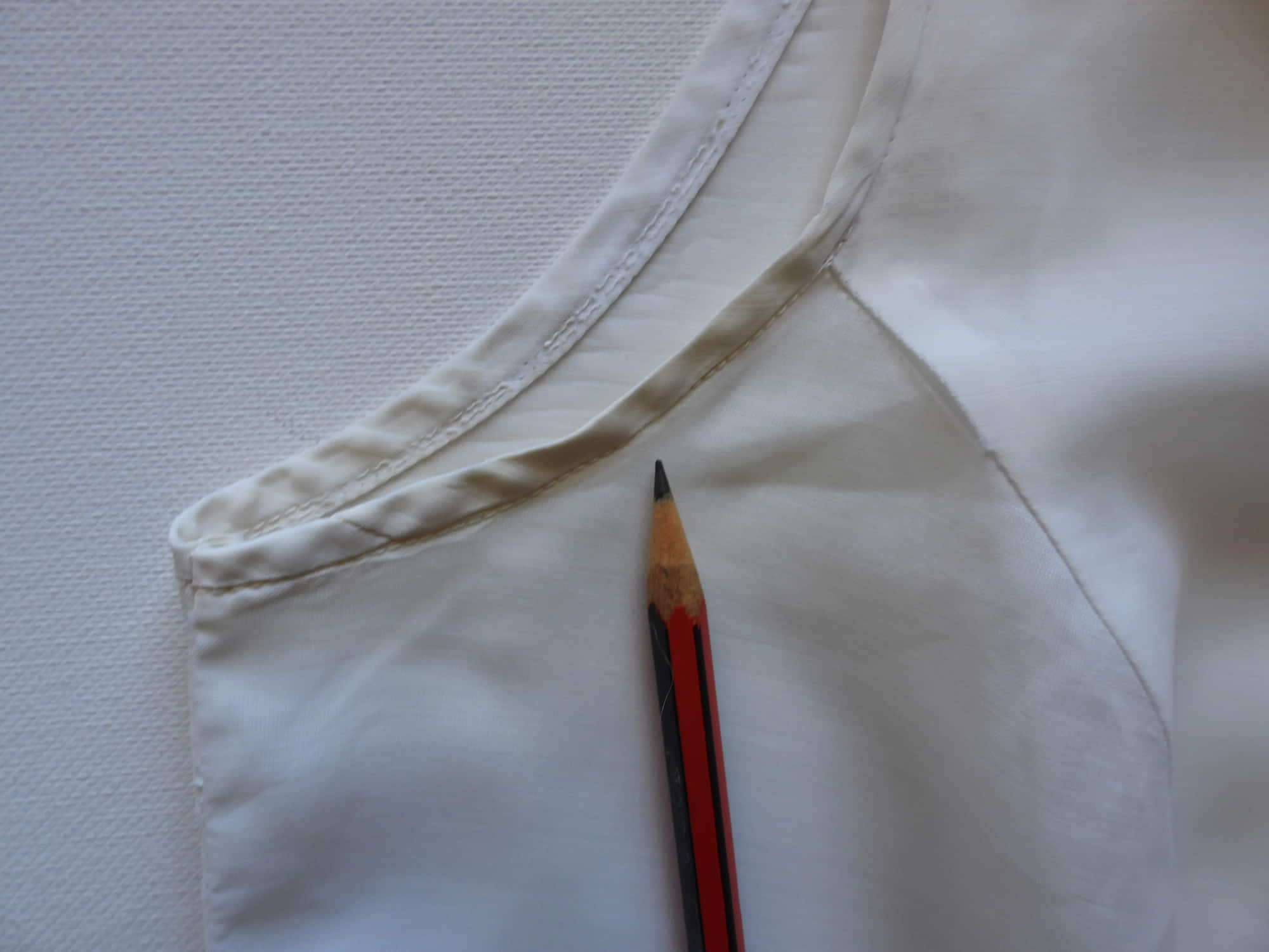 Tennis dress is decorated at centre front with eyelet embroidery. It has princess seaming and closes at the back with a zipper. The dress is semi sheer. The fabric appears to be an early form of polyester or maybe nylon, there's no fabric tag. The label reads "A Belle Garment Exclusive Model" - early 1960s. Medium
